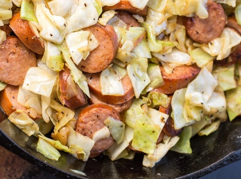 Need an easy low carb, one pan dinner? I've got you covered! This Keto Sausage and Cabbage Skillet is ready in under 20 minutes and has less than 6 carbs per serving! #keto